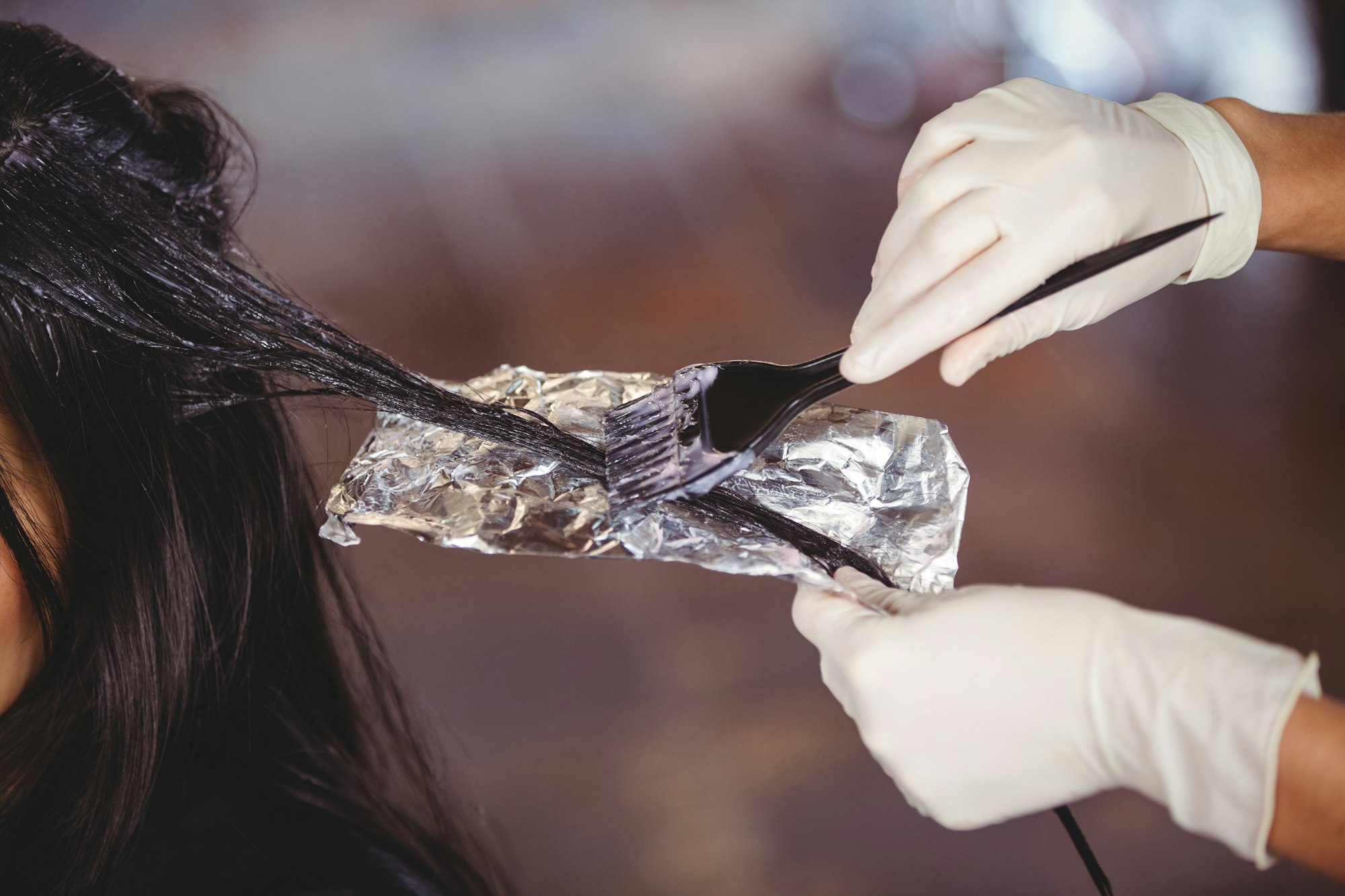 Hairdresser dyeing hair of her client